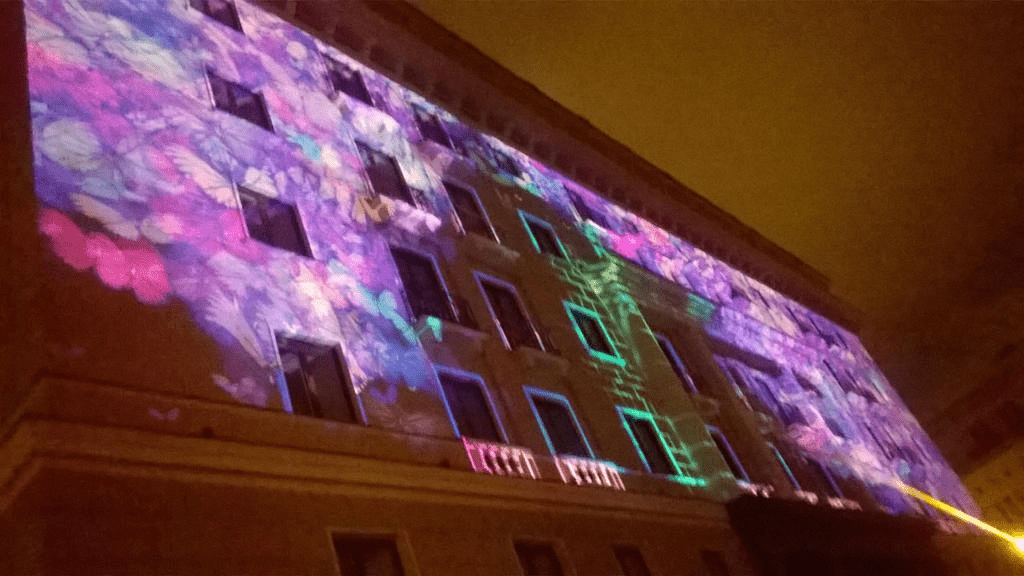 Hotels facade, alit with purple colours, butterfly shapes