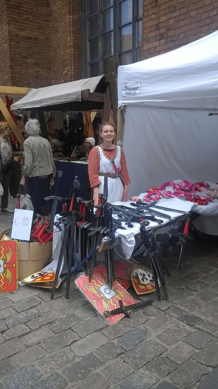 A stall selling toy weapons, in the medieval portion of a summer fair