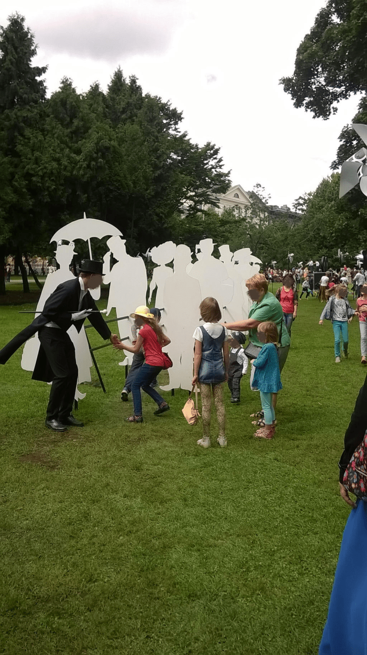 Obstacle course from the front, fair worker dressed in a fancy tux-looking attire directing the little attendants where to run