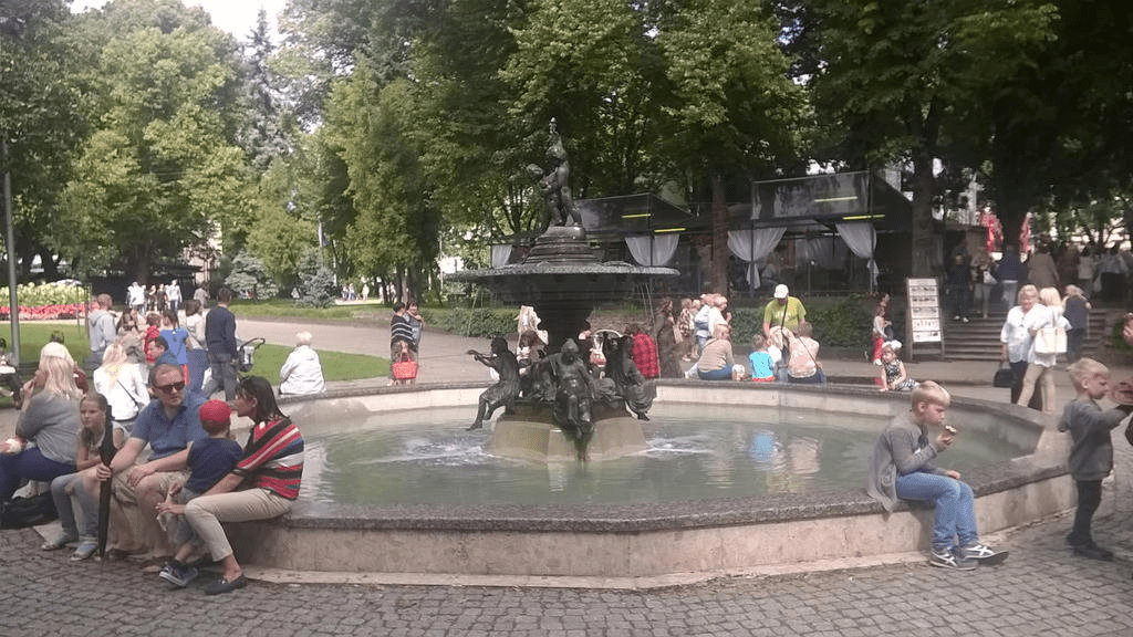 People sitting on or around a fountain in the park