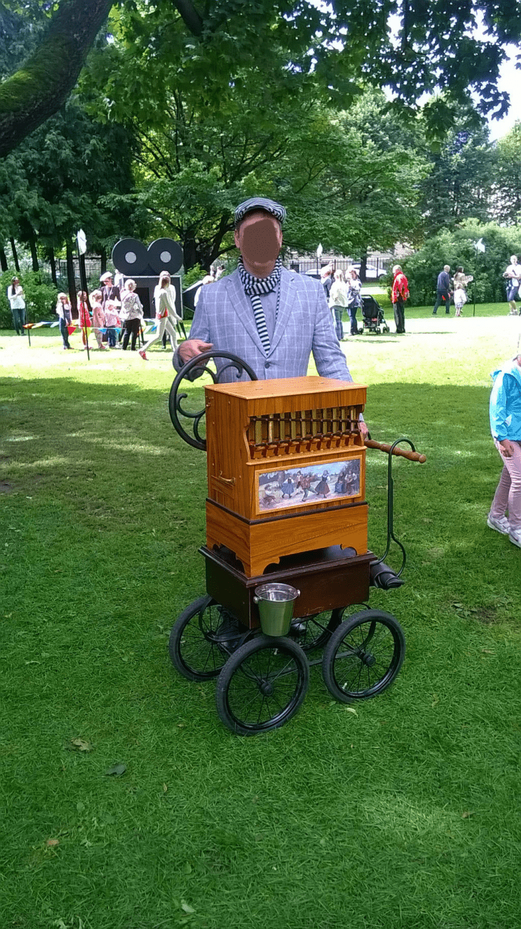 A different musician, playing the organ grinder