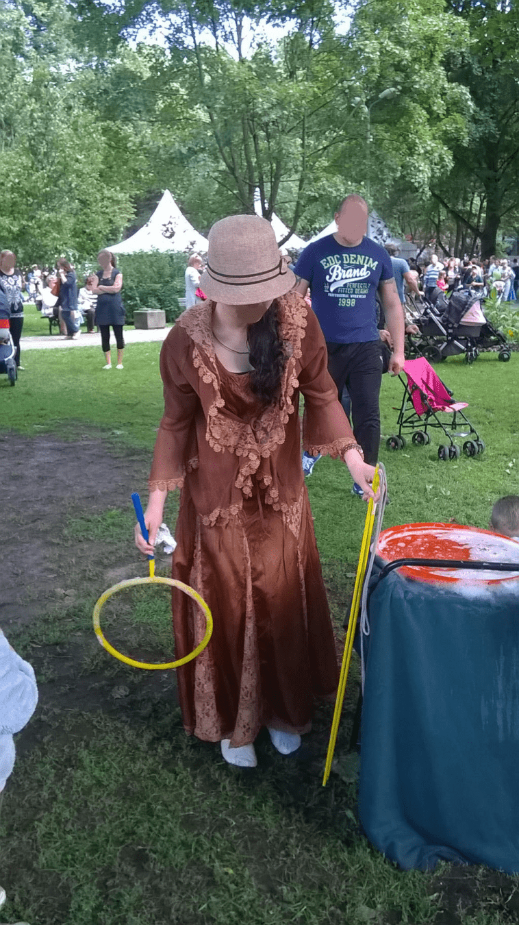 Photo of a fair worker in 1900s outfit, readying the bubble wand for the viewers