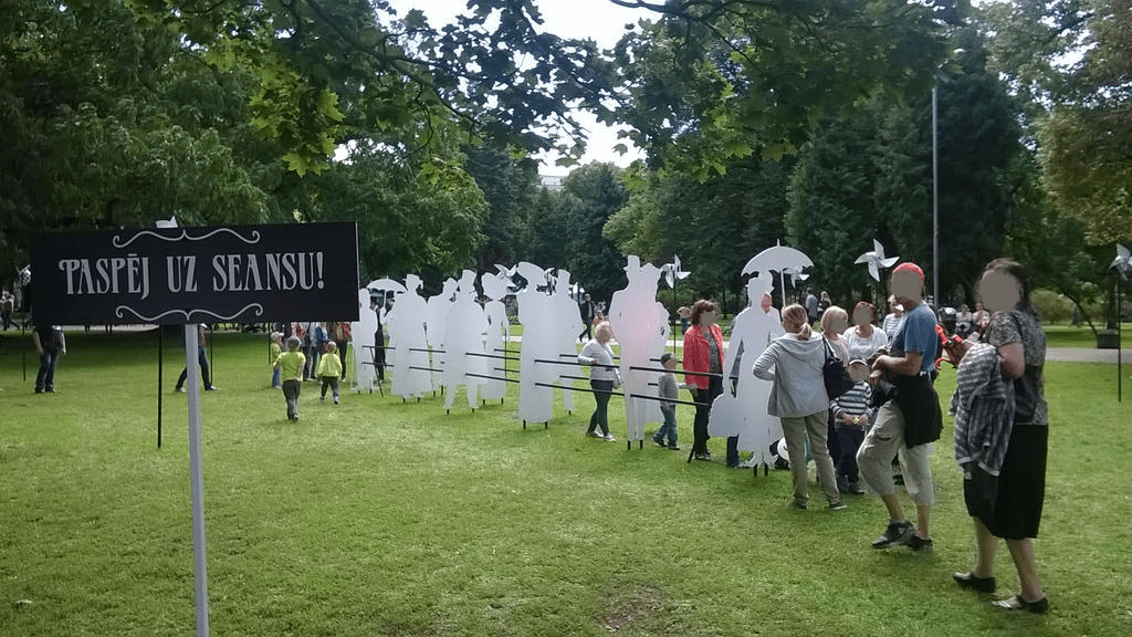 An obstable course, with cutouts that look like old timey folks standing in line, with a sign saying "Make it to the Seance", people are lining up and running through it