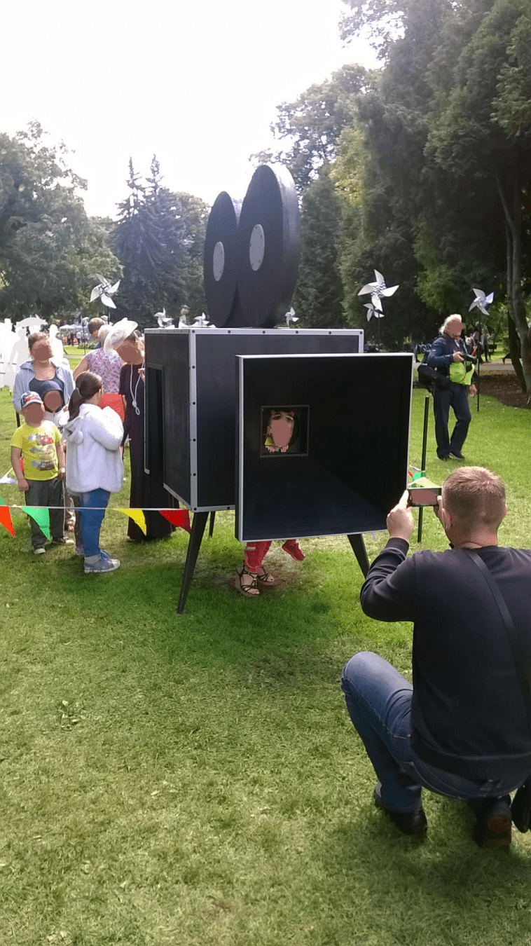 Kids in the camera, with a big line leading to the camera, enjoying the photo session