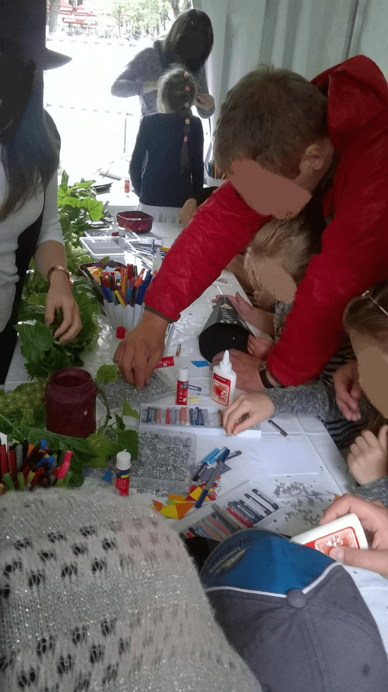 Kids and parents at the table, working on art projects