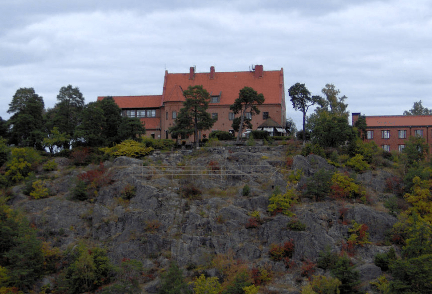 Big reddisg home atop of a cliffy island