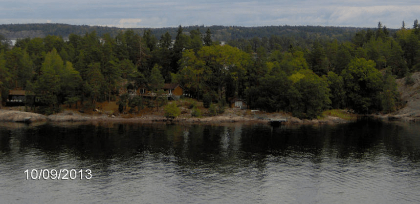 Forest island in the Stockholm Bay, with a bunch of houses and docks on it