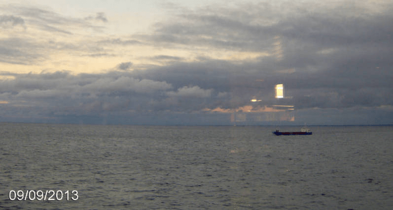 Photo taken of the Gulf of Riga, with a long ship in the distance, from the cruise ship Tallink