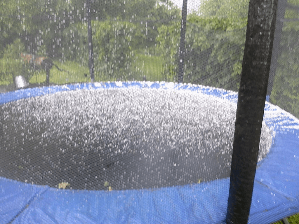 Photo of a trampoline partly covered in hail