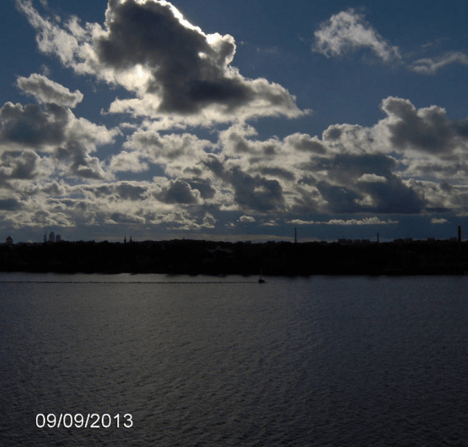 Photo taken from the cruise ship Tallink, looking over Daugava, looking more upwards to see the big thick cloud covering the sun