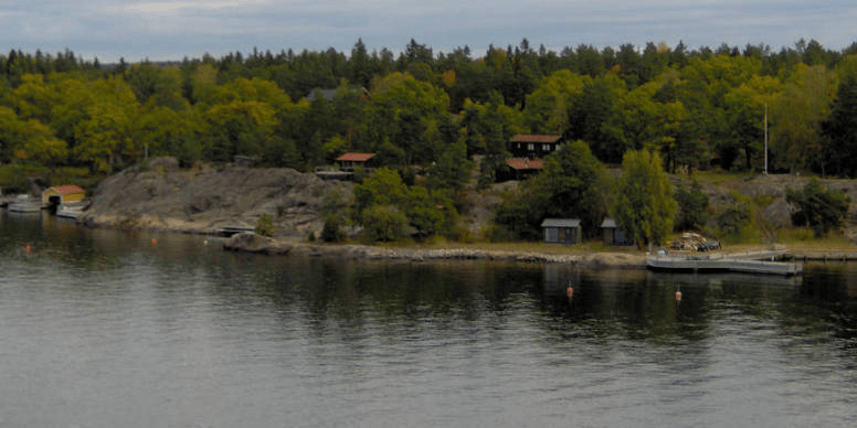 Long forested island with homes and docks on it