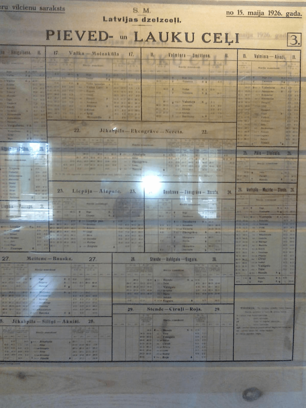 Old time train schedule printed on glass attached to a wall