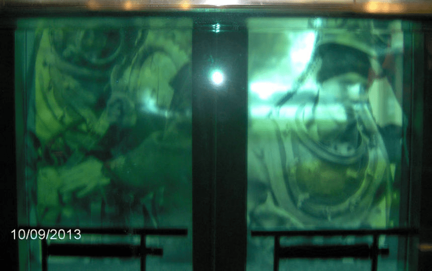 Green tinted stained glass with drawings in them, left is a man and the right is a woman