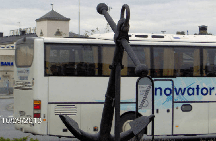 Anchor statue in front of the Stockholm Port, with a bus going by