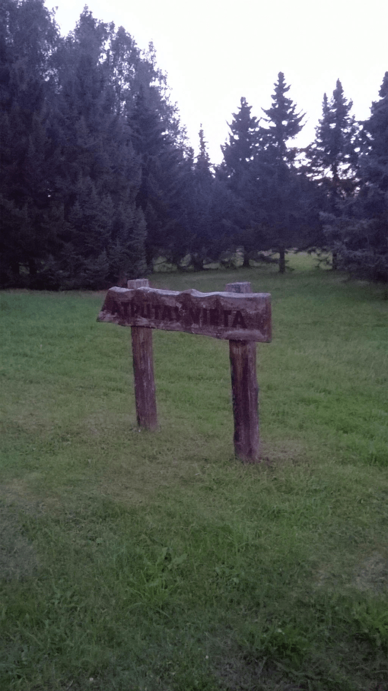 A wooden sign pointing to the Rest Area, written in Latvian