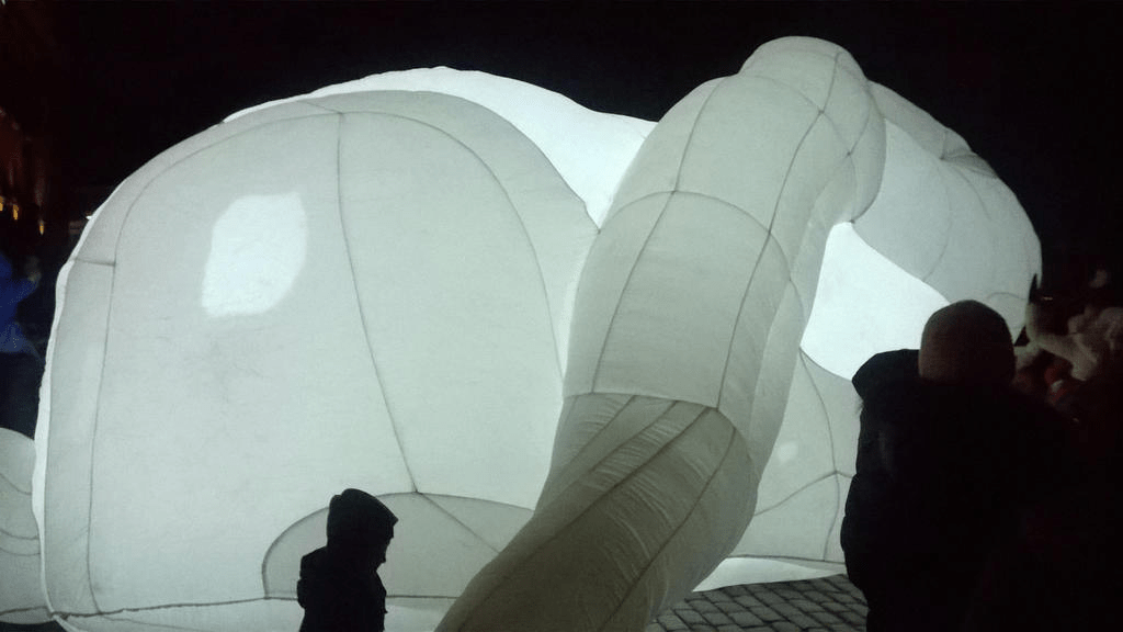 A big balloon bunny is lying down, bright light glowing from inside of it