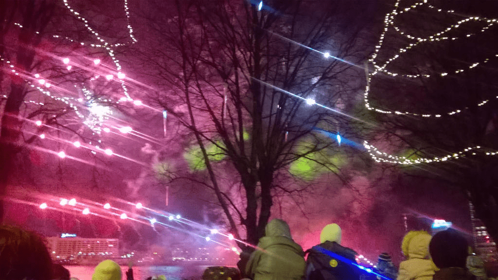 Red and blue fireworks are shooting up from the sky