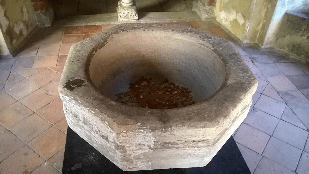 Stone fountain with coins inside of it