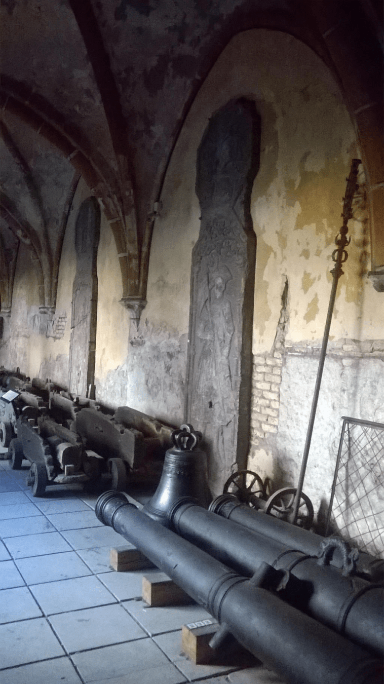 Cannons on the ground and stone slabs by the wall