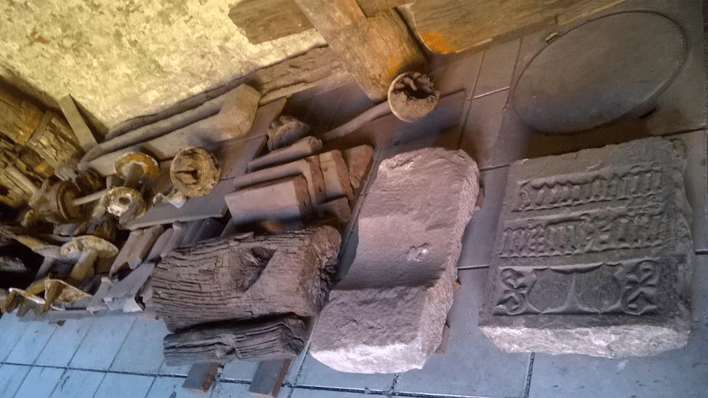 Stone and wooden objects, all placed on the ground by the wall