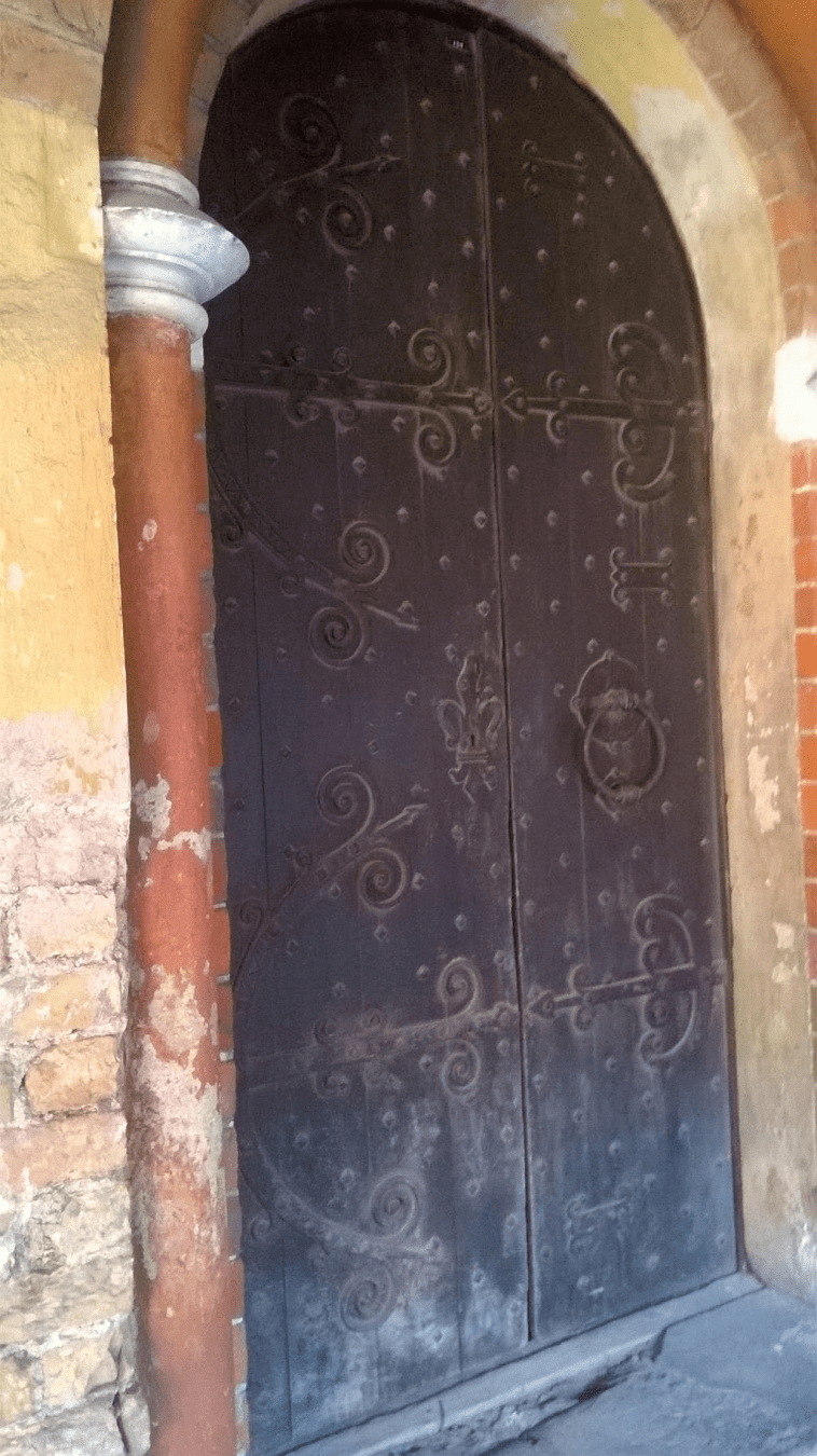 Old wooden door in an old cathedral hallway