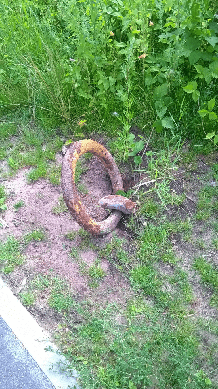 Metal ring, attached to the ground, rusted