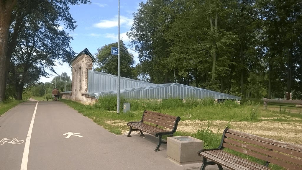 Ruins of a third building, by the Promenade path, with park chairs on the side, with metal covers placed over it, to protect it from the elements