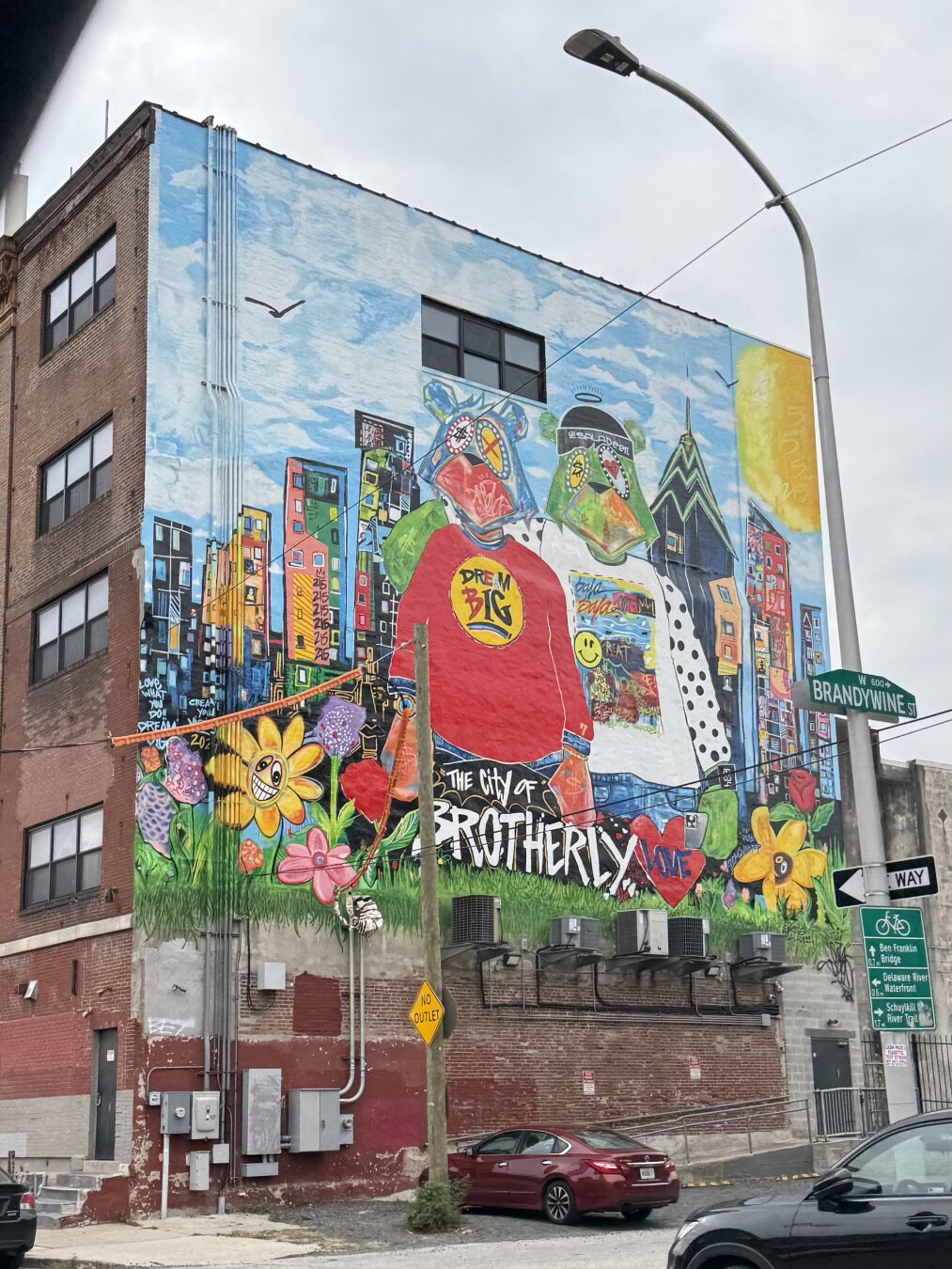 A mural on the side of a building that says “The City of Brotherly Love”