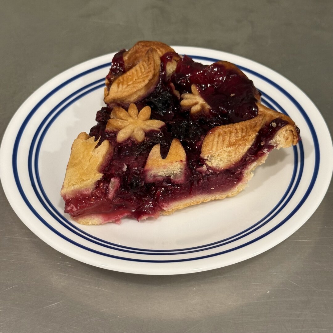 A slice of berry pie on a plate