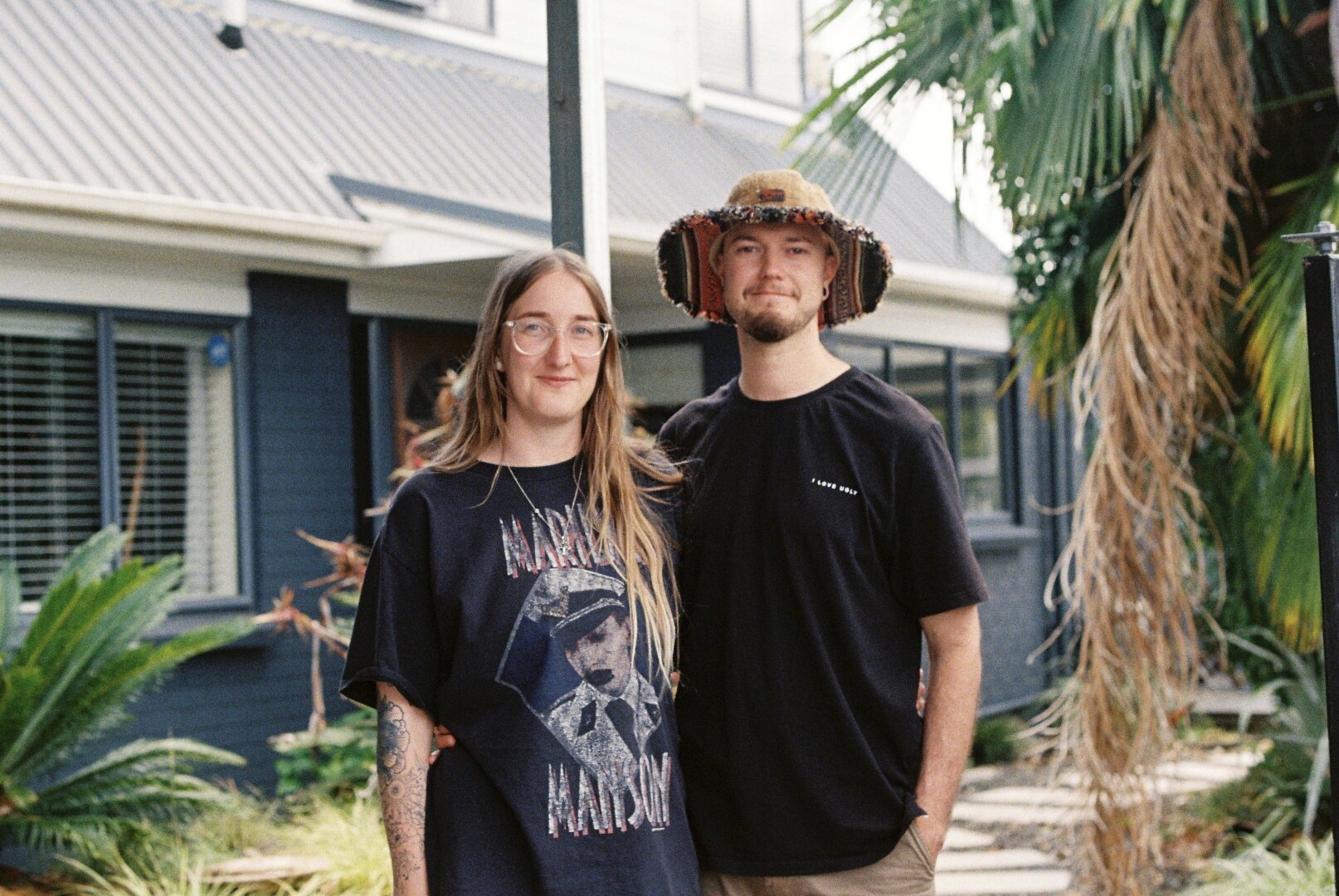 A couple standing in front of a newly purchased house.