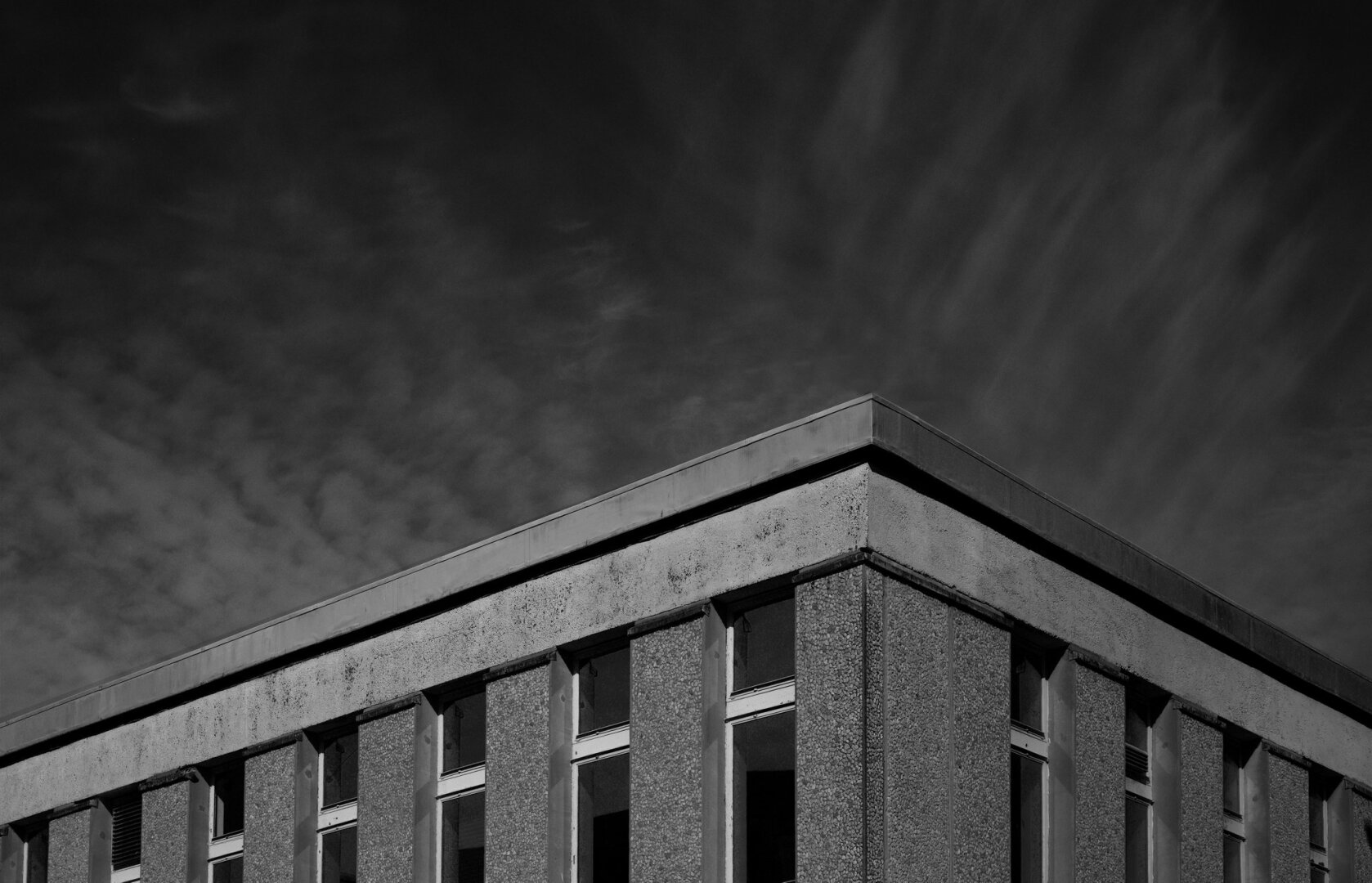 Clouds over corner of building, black and white