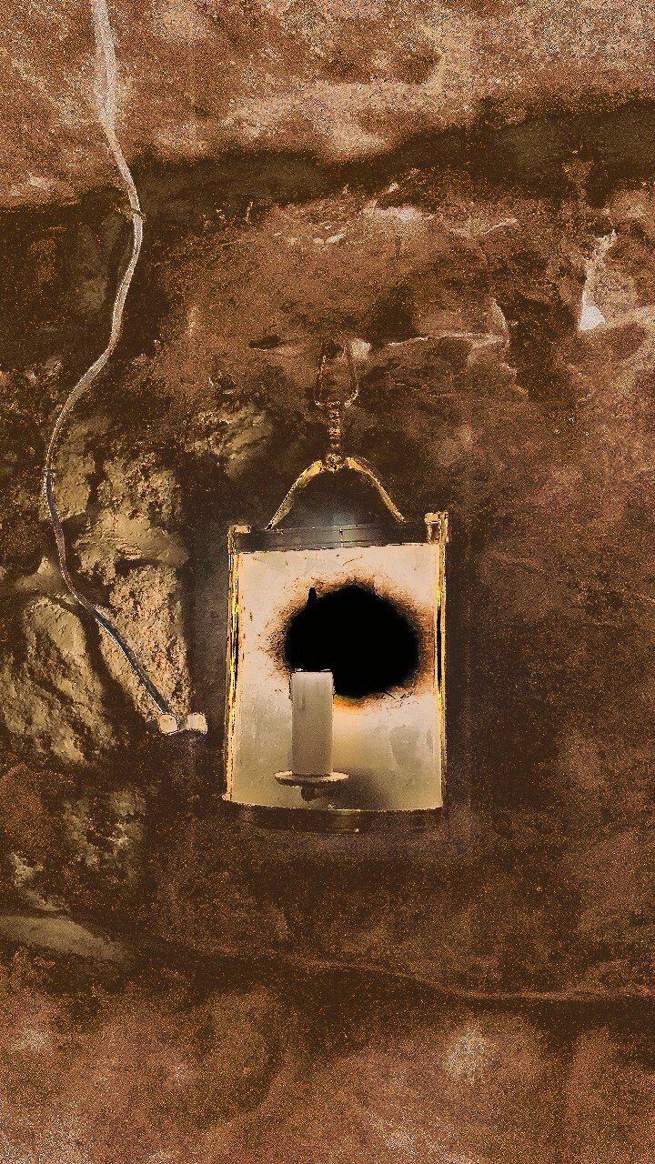 Une bougie sur un mur de pierre, avec la luminosité distordue de façon à ce que la flamme paraisse noire.

And candle on a stone wall, with light distorted so as the flame looks dark.