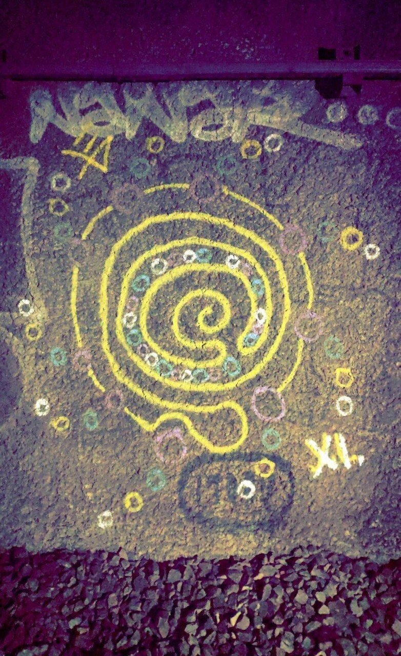 Un graffiti représentant un soleil qui est aussi un labyrinthe