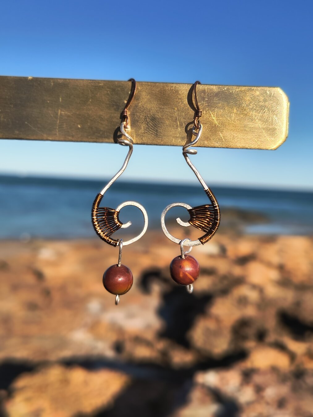 Chapter 10 — They Always Come Back

🌊 A custom pair for a friend who wanted to wear the ocean, the music, and the movement.
Curves that catch the light like a wave’s edge, beads that sway with the beat.

Every now and then, she messages me in a small panic — “I’ve lost one!”
And somehow, every time, it finds its way back to her. 🤞

Some pieces just refuse to leave their person.

#WireWrapping #CustomJewelry #OceanInspired #MalikasRealm #Madewithsoul