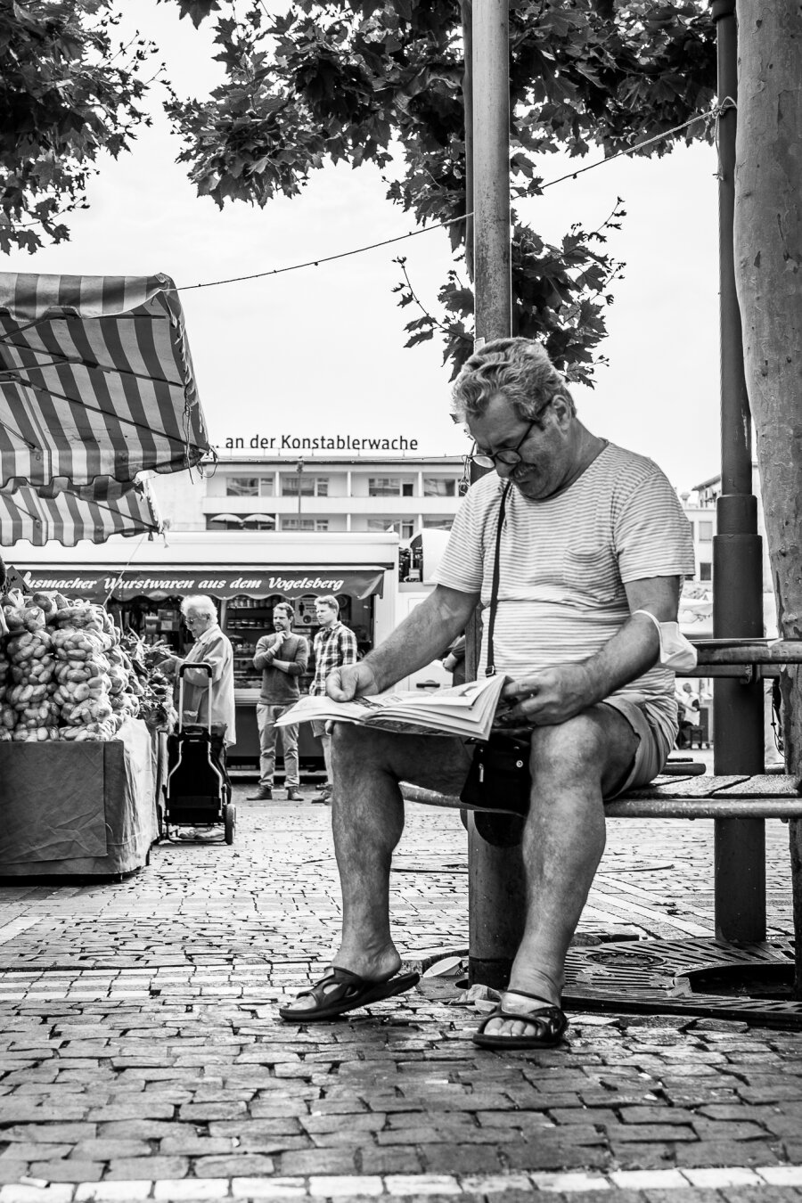 Man reading Newspaper at the market of Konstablerwache in Frankfurt am Main.
