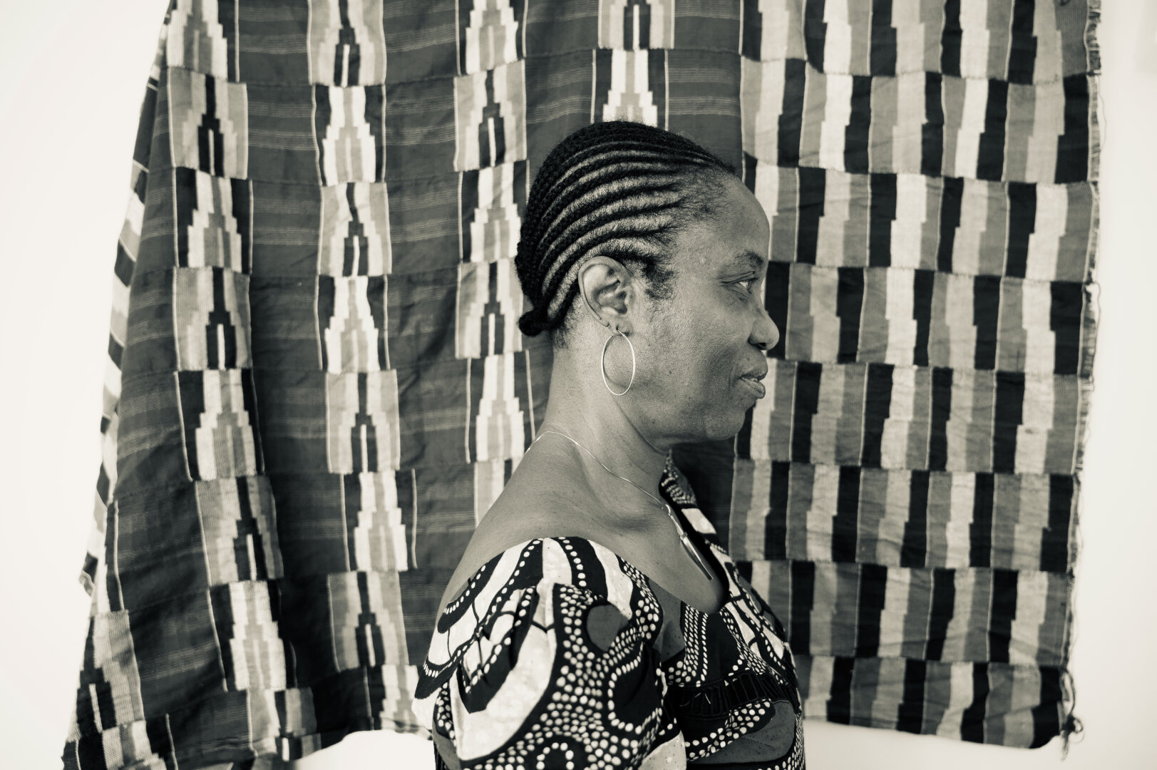 My mother in profile with the background of kente cloth