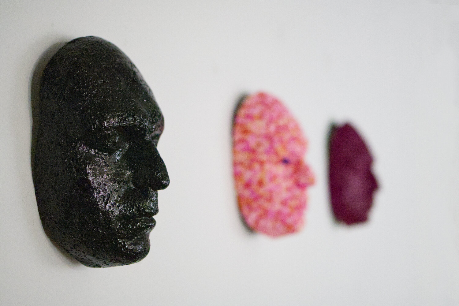 portrait en papier maché de l'artiste ali honarvar accroché au mur