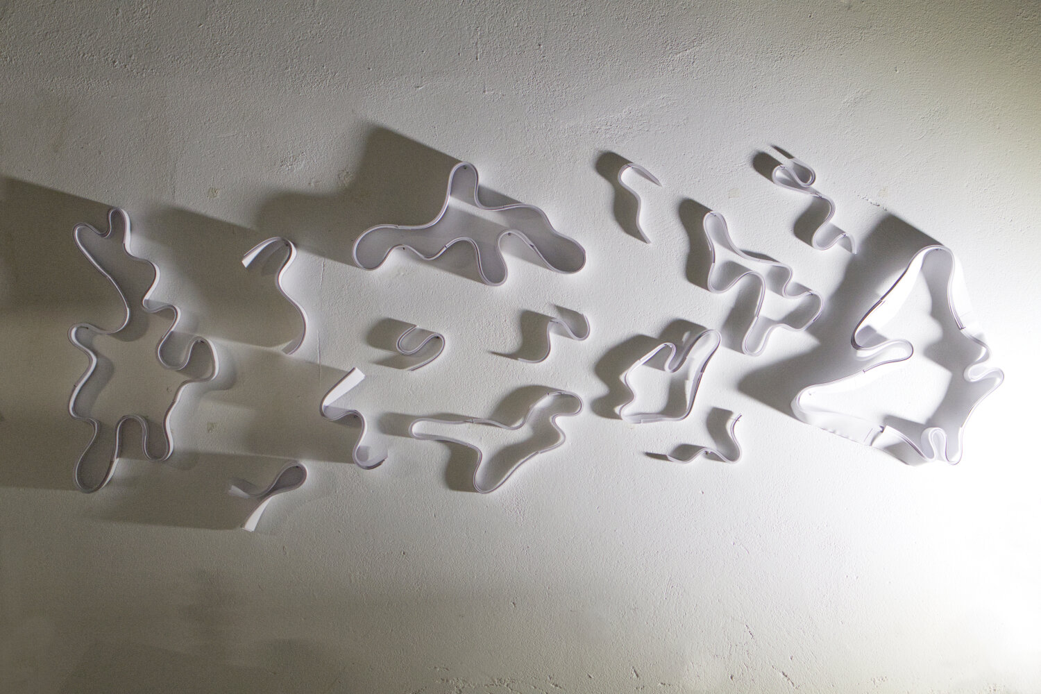 papier blanc torsadé au mur, vue d'ensemble d'une sculpture en papier mural