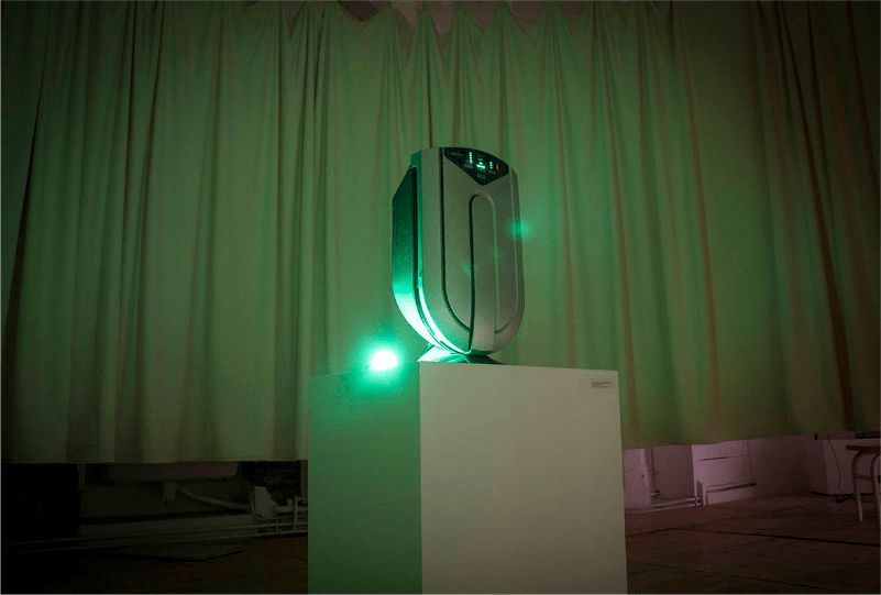 photographie de l'installation, un stérilisateur d'air est posé sur un socle entourée d'une lumière verte