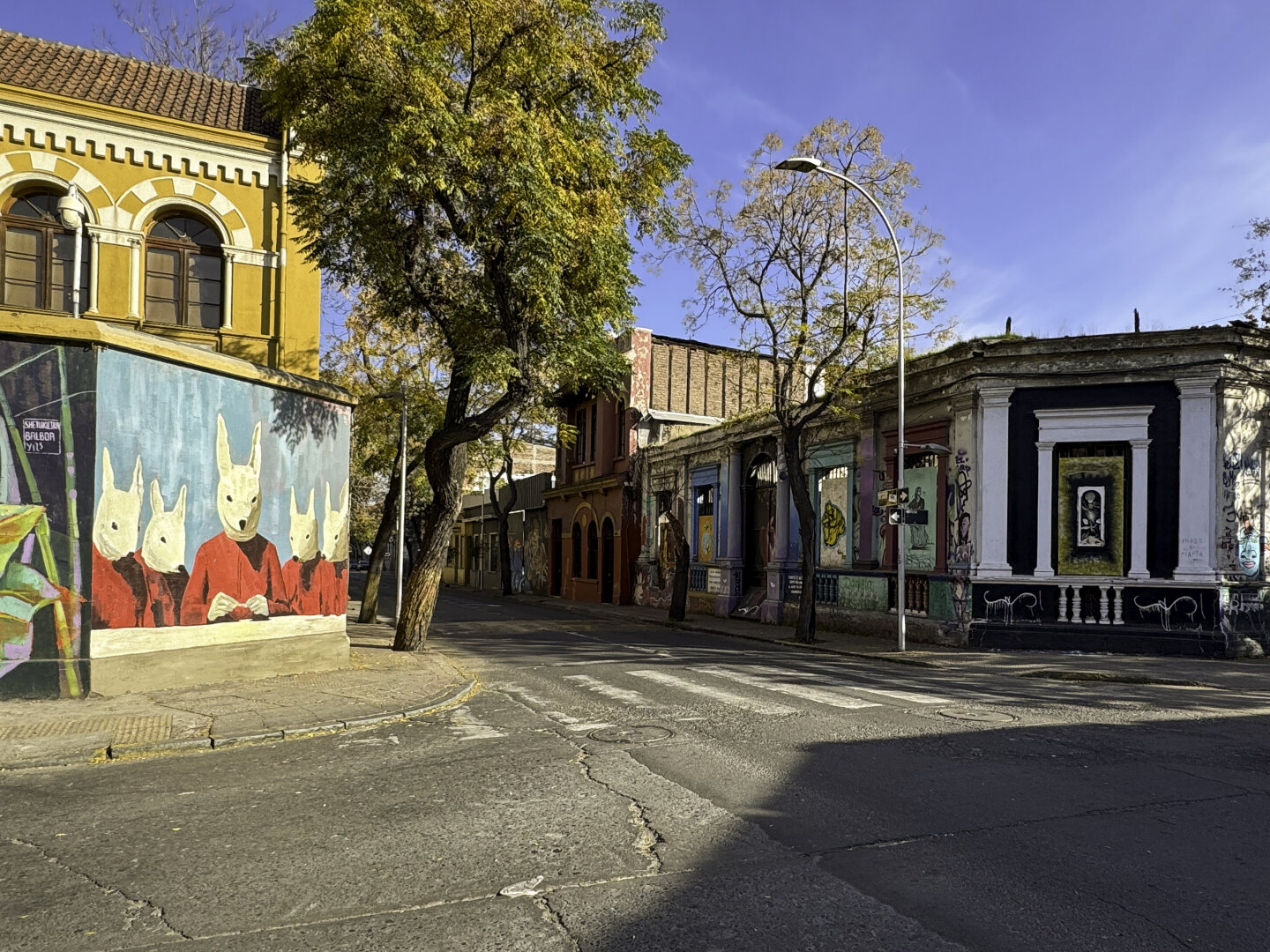Street corner with small brick buildings and colorful murals