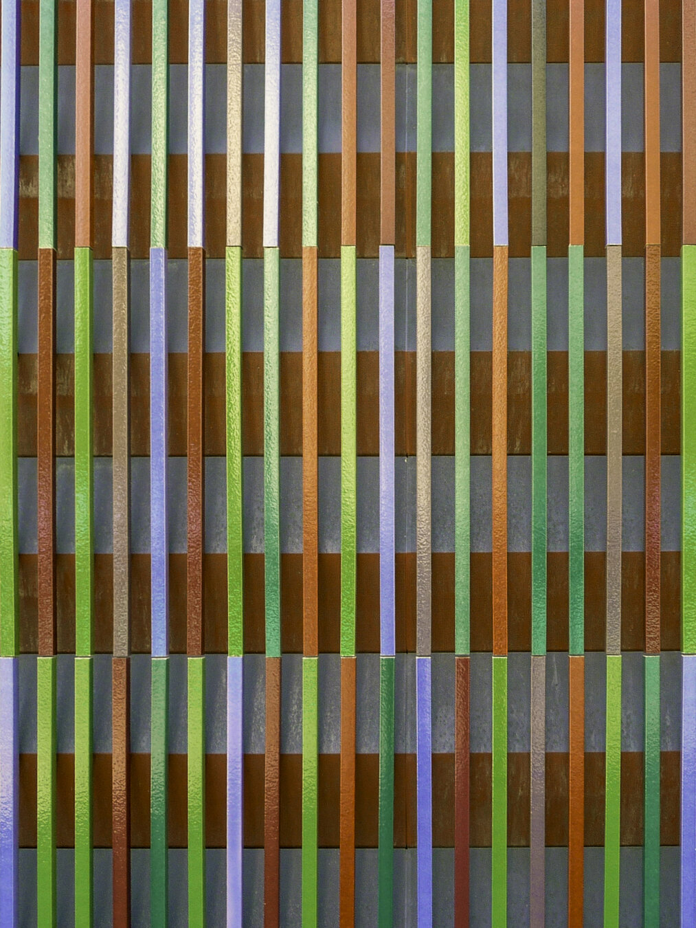 Close-up view of a building facade featuring multiple narrow vertical strips projecting out in multiple colors.