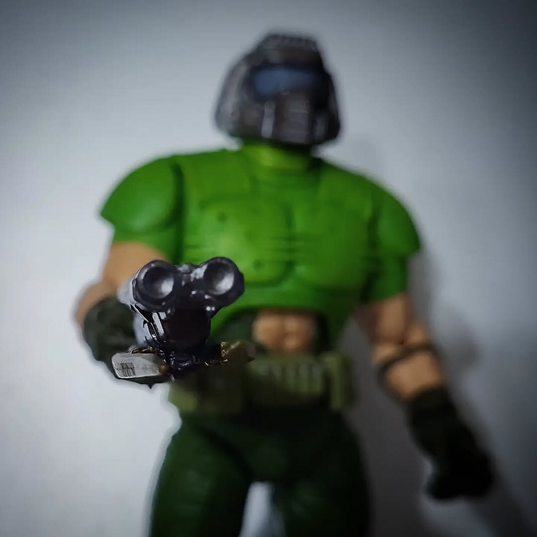 A photo of the Doom guy action figure, the double barrel pointing at the camera