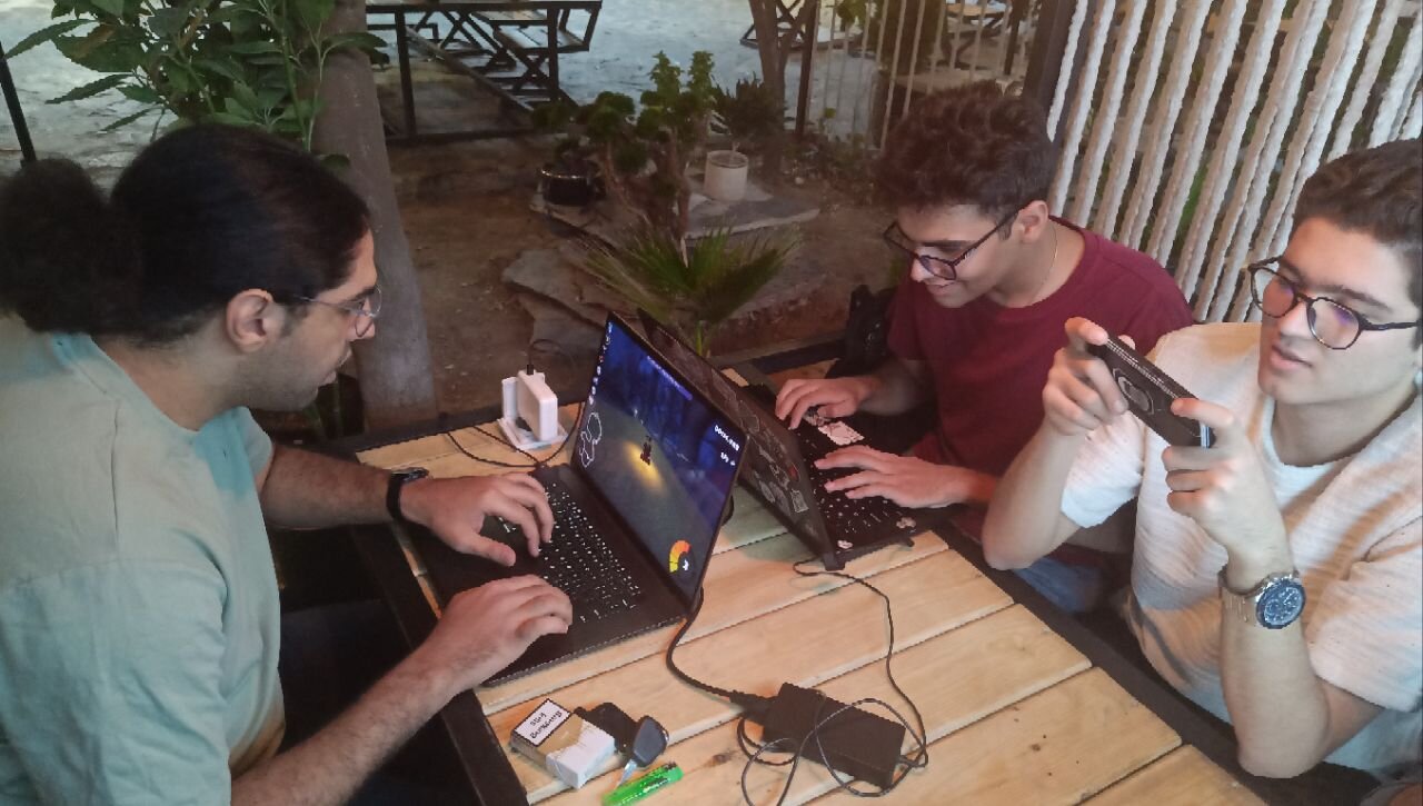 یه تیم سه نفره داخل میز نشستند و با هم بازی میکنند