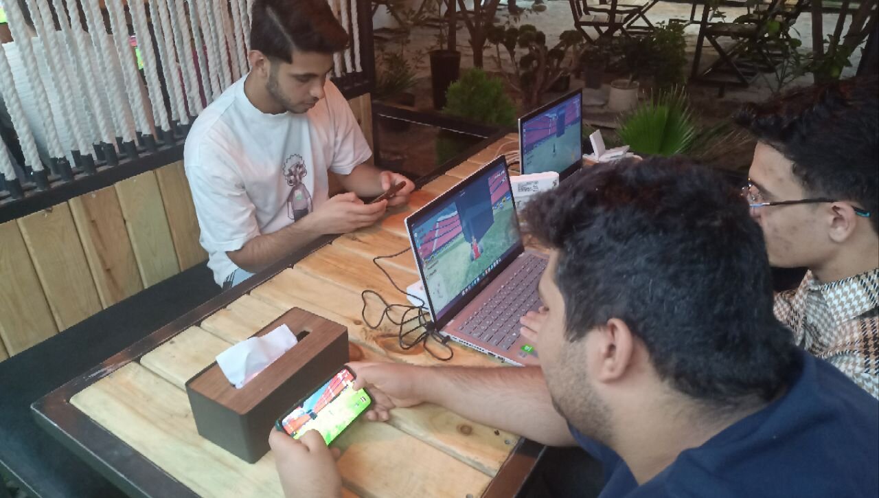 گروه سه نفره با دو لپتاپ در حال بازی شبکه‌ای