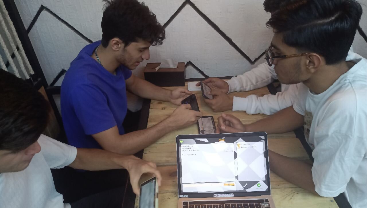 گروه چهار نفره با تلفن همراه و لپتاپ