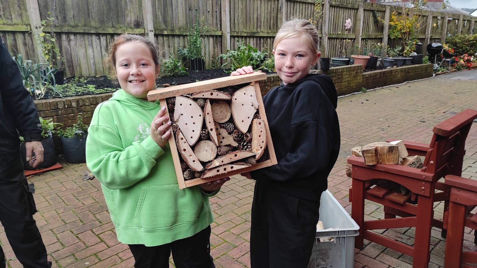 Two girls holding bug hotel