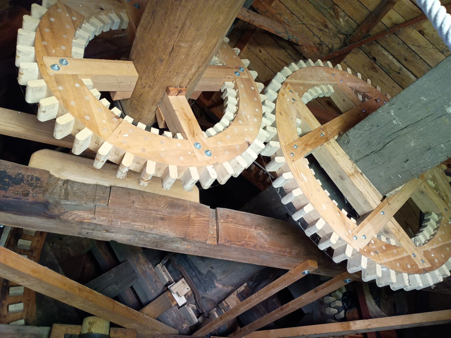 Foto von großen Holzzahnrädern, die Teil einer Mühle sind.