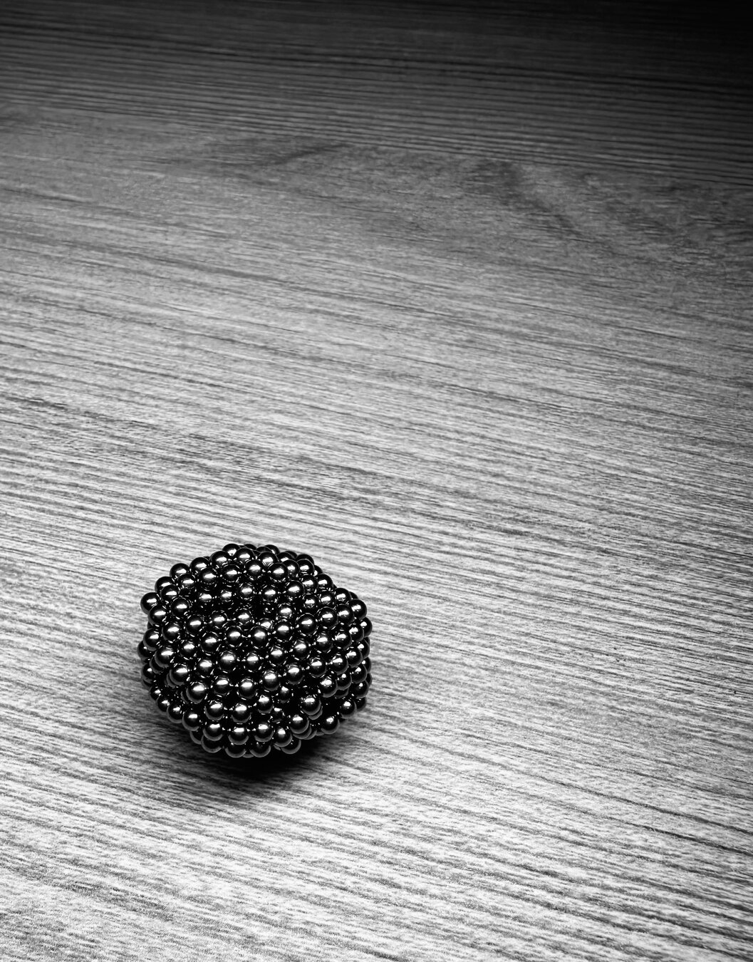 Small ball made of small ball magnets on wood.