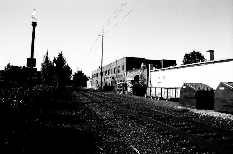 A railway track runs along the backside of shops.