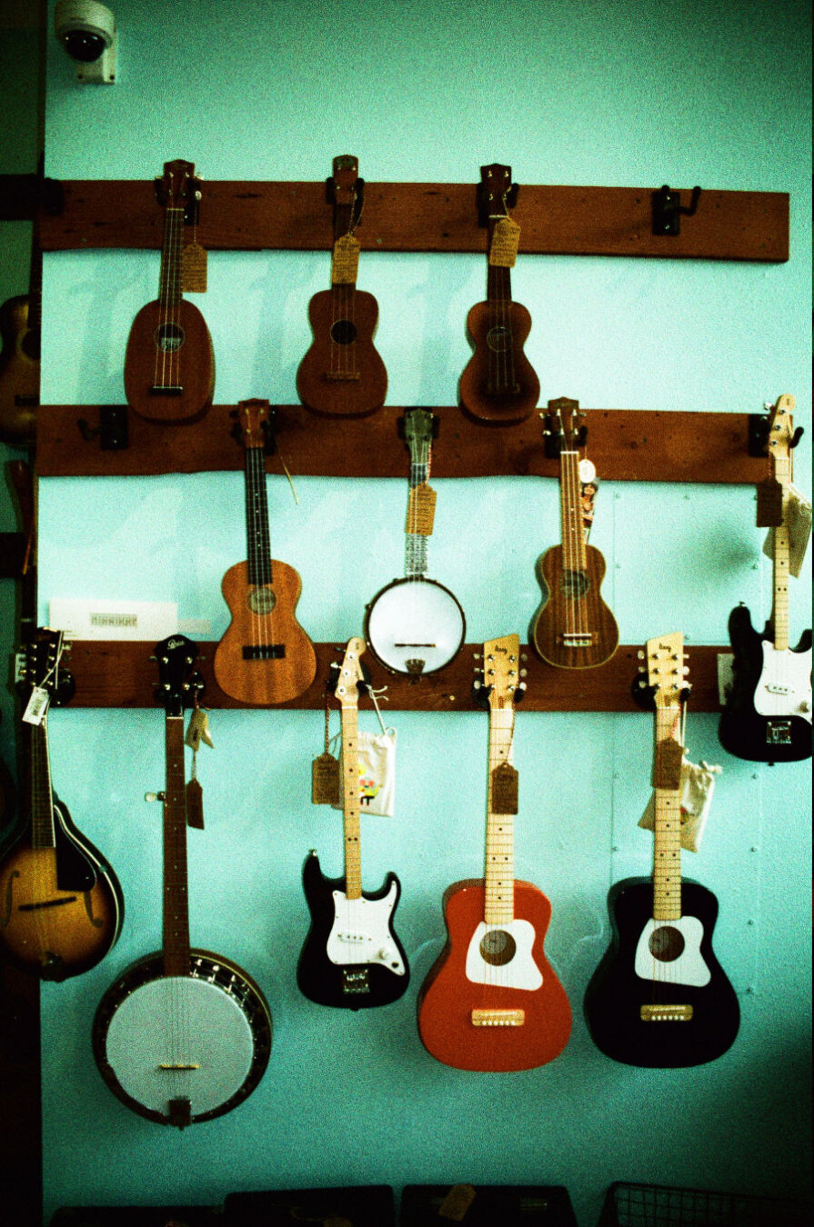 A wall of guitars, ukeleles, mandolins, and banjos.